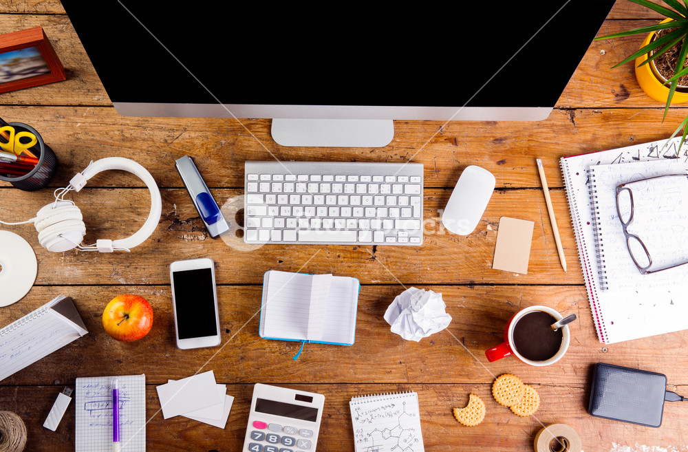 Photo of a desk with a lot of stuff on it.